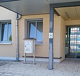 [Bild] Gebäudeansicht des Arbeitsgerichts Nordhausen mit einem roten Pfeil auf den Nachtbriefkasten vor dem Haus